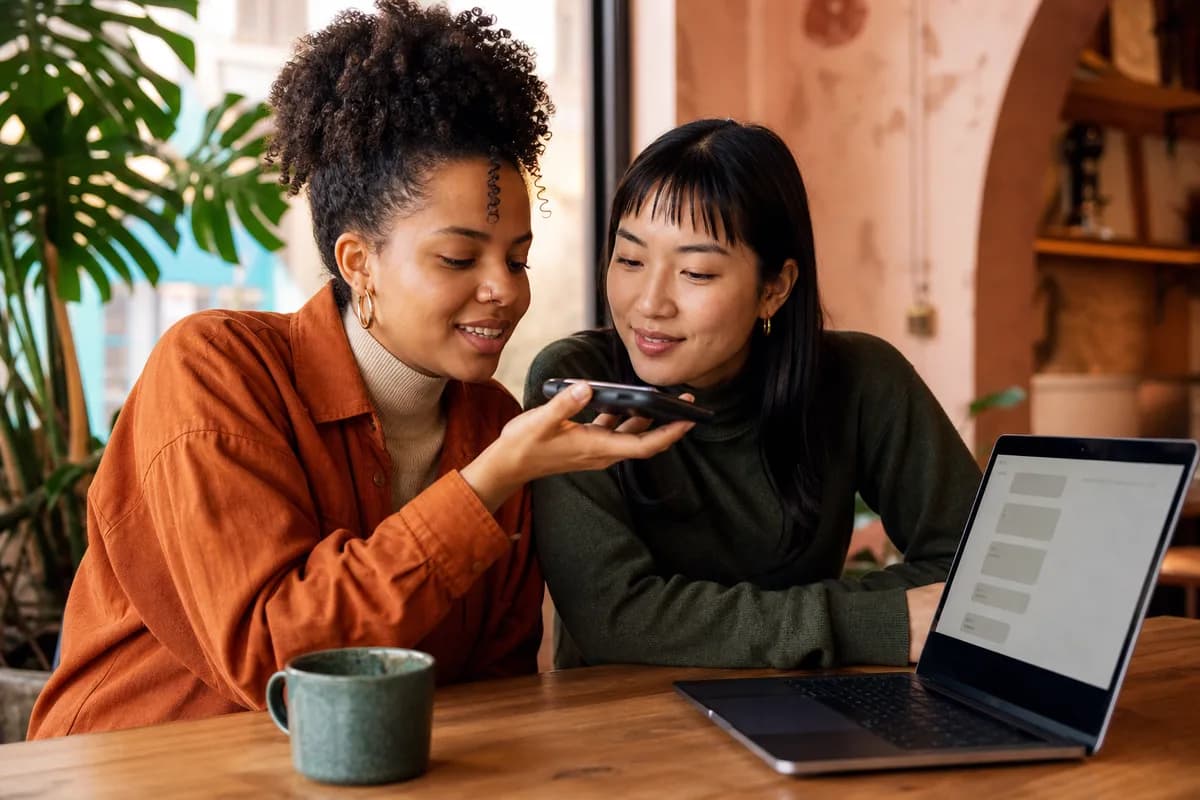 People checking a mixed-language WhatsApp voice note and Tamil transcript together in a café